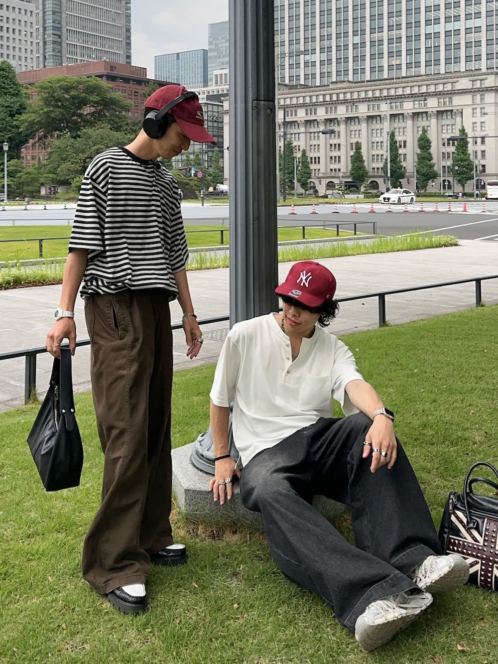 ホワイト系のTシャツ/カットソー、ブラック系のデニムパンツ、ブラック系のバッグを着用したメンズの夏コーディネートの2枚目の写真