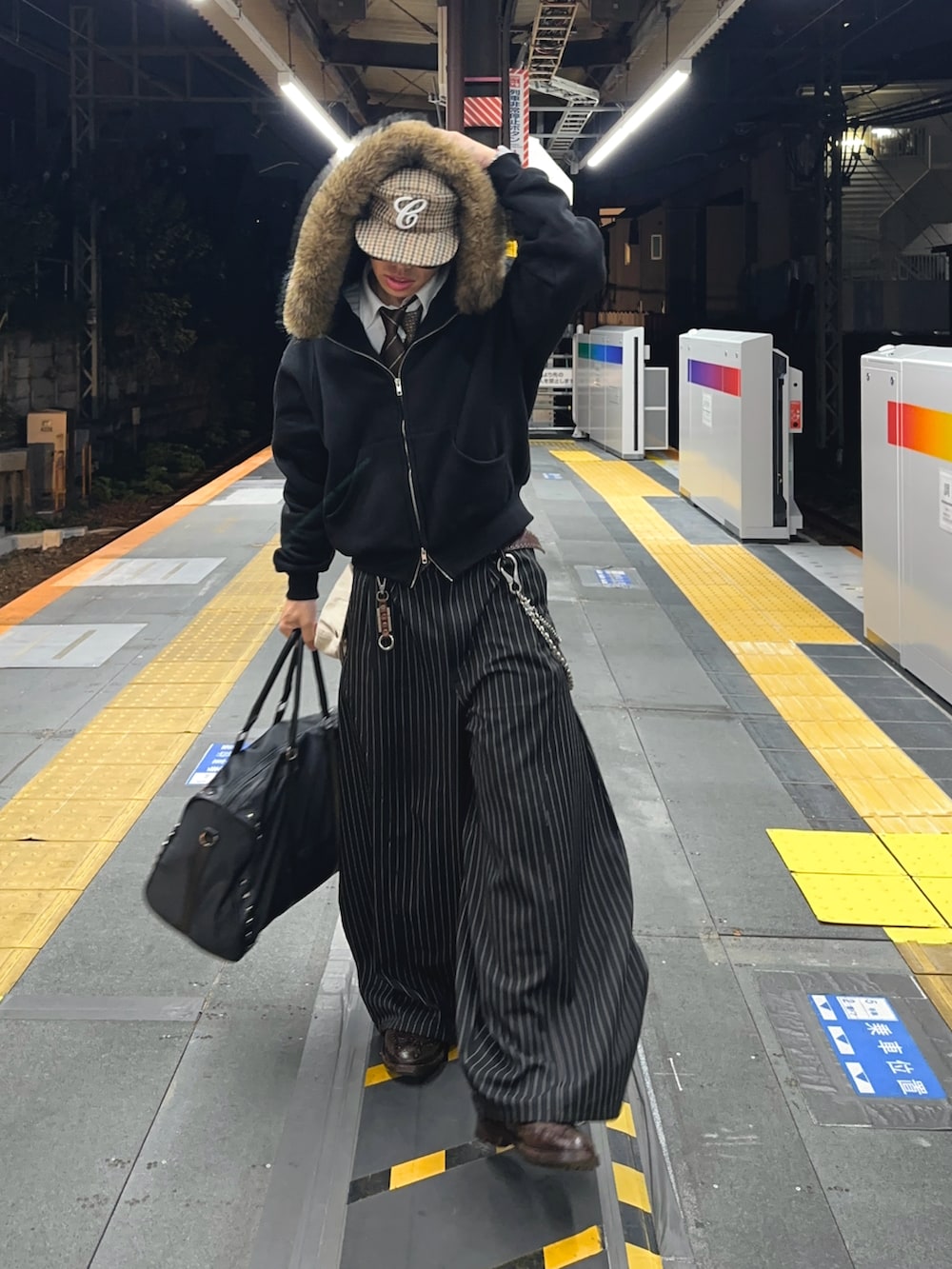 ブラック系のボストンバッグ、ブラック系のスラックス、ブラック系のパーカーを着用したメンズの秋コーディネートの2枚目の写真