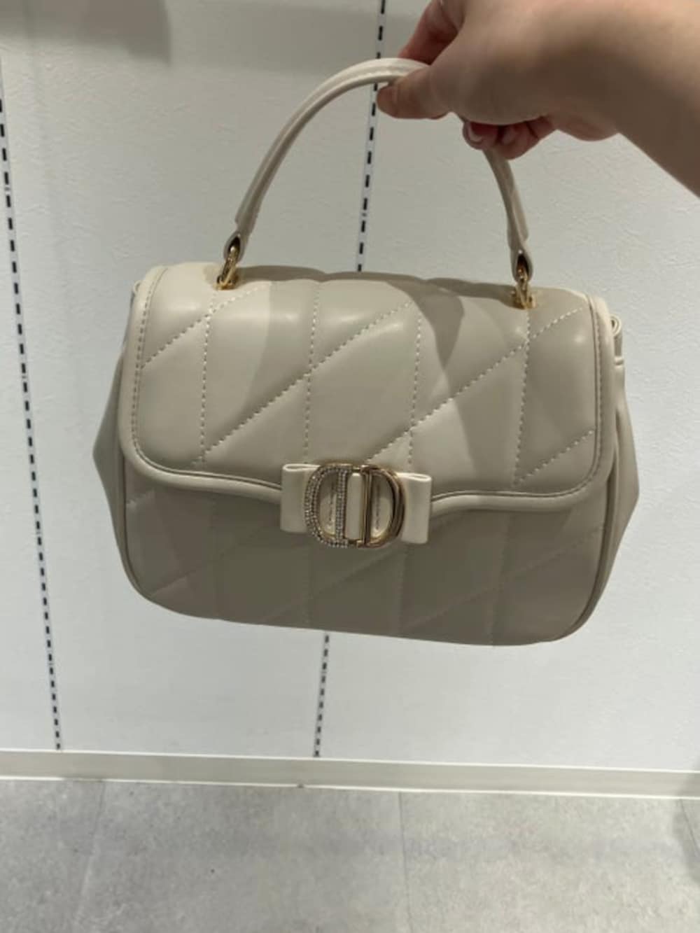 ホワイト系のサンダル、ブルー系のワンピース、ホワイト系のブルゾンを着用したレディースの春コーディネートの2枚目の写真