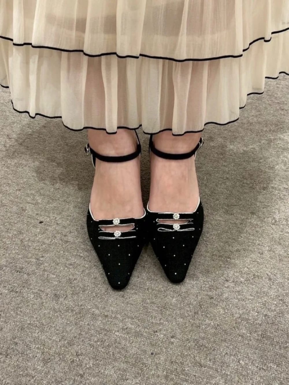 ブルー系のデニムジャケット、ブラック系のワンピース、ブラック系のショルダーバッグを着用したレディースの春コーディネートの2枚目の写真