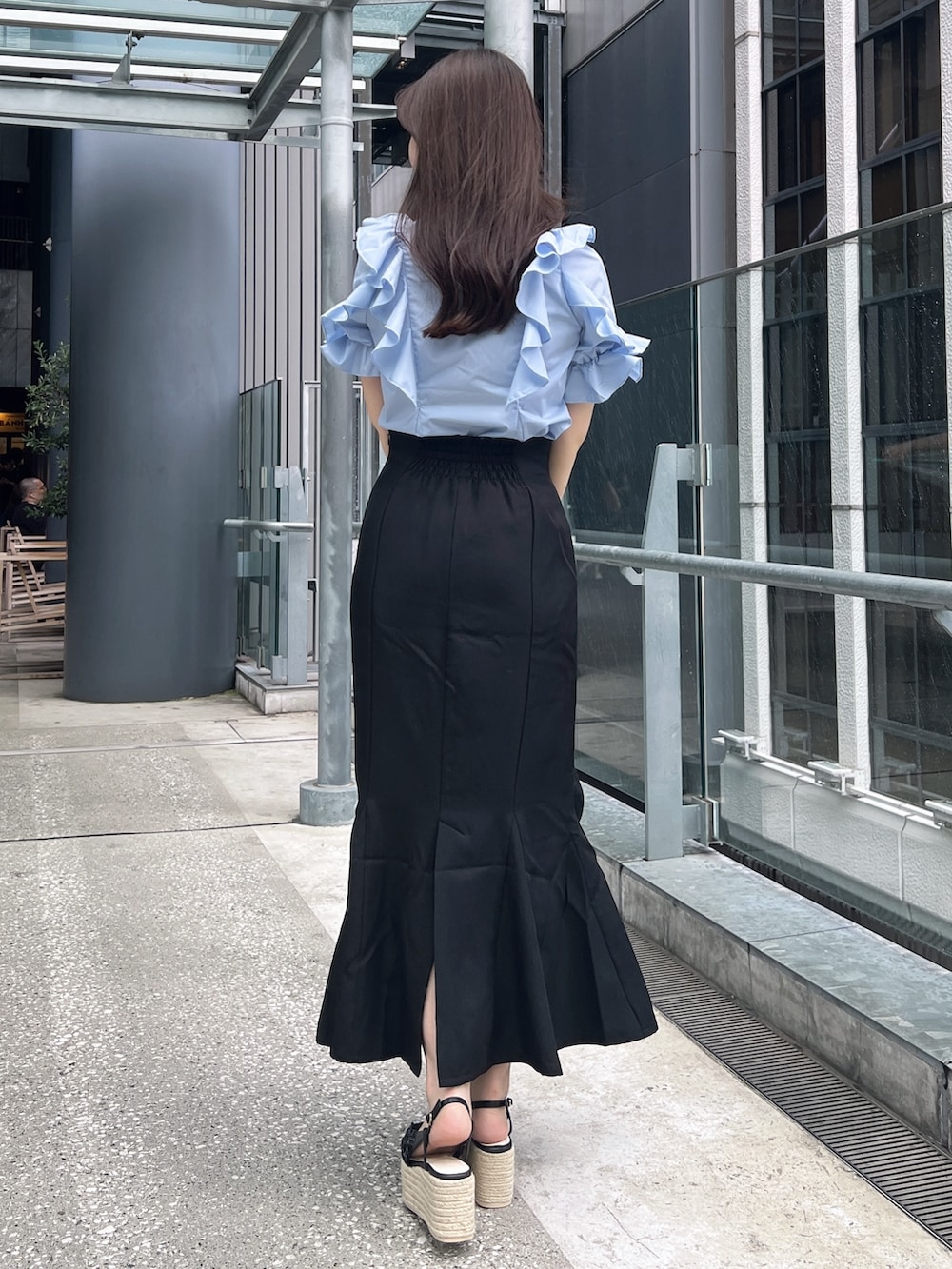 ブラック系のスカート、ブルー系のシャツ/ブラウス、ブラック系のサンダルを着用したレディースの夏コーディネートの3枚目の写真