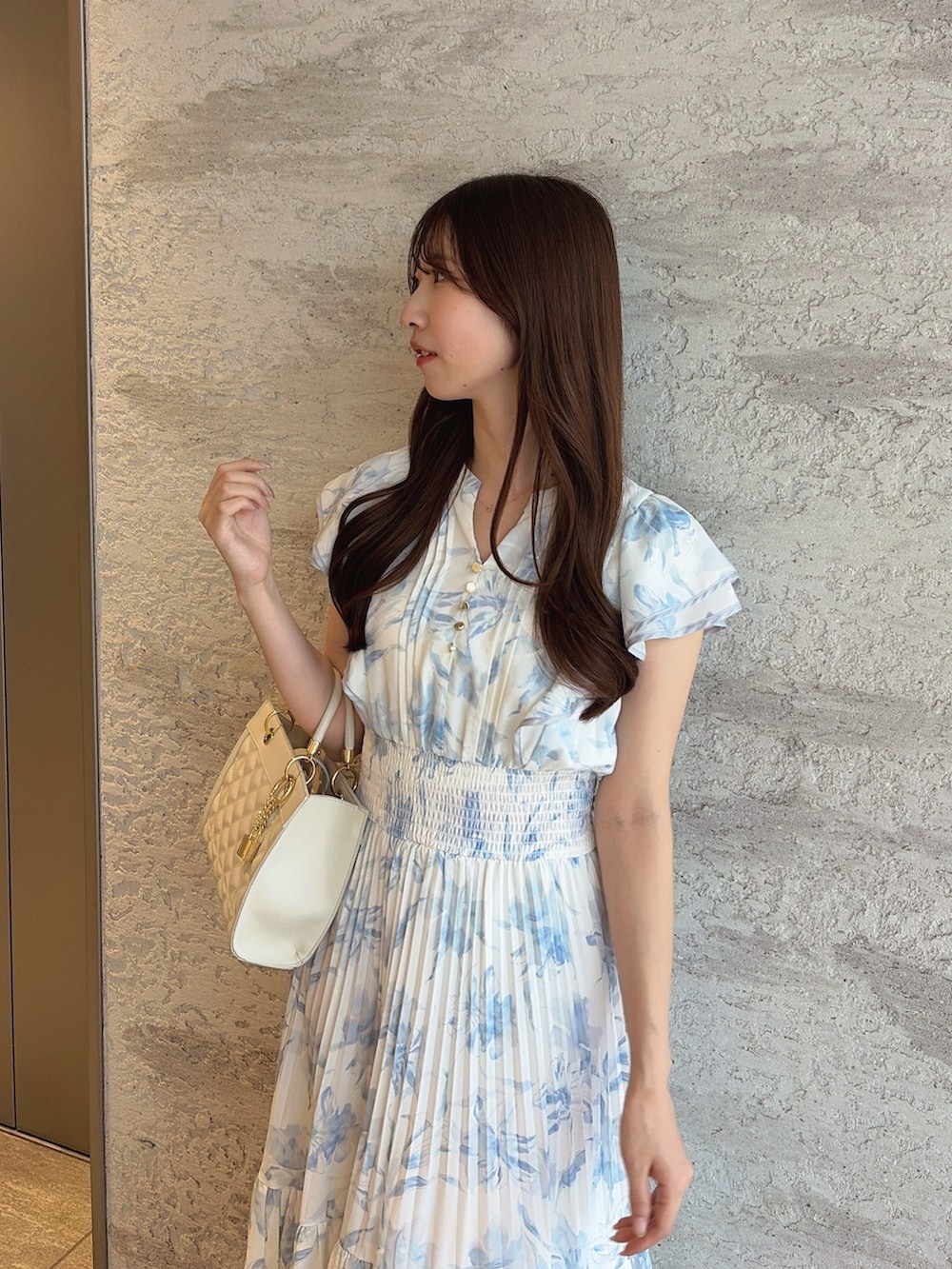 ブラック系のパンプス、ホワイト系のハンドバッグ、ブルー系のワンピースを着用したレディースの夏コーディネートの5枚目の写真