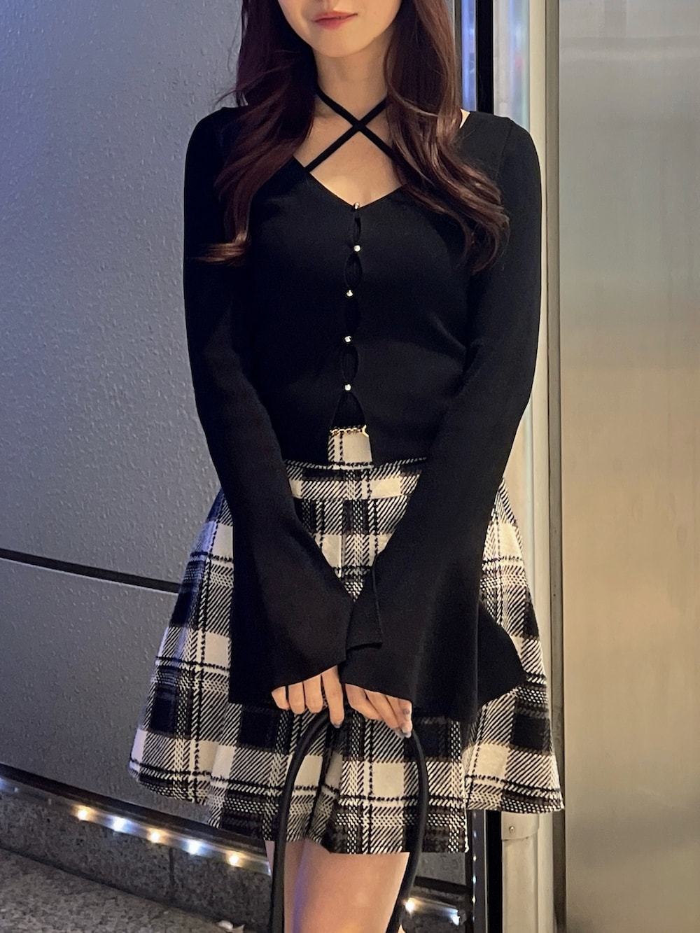 ブラック系のスカート、ブラック系のニット/セーター、ブラウン系のローファーを着用したレディースの冬コーディネートの8枚目の写真