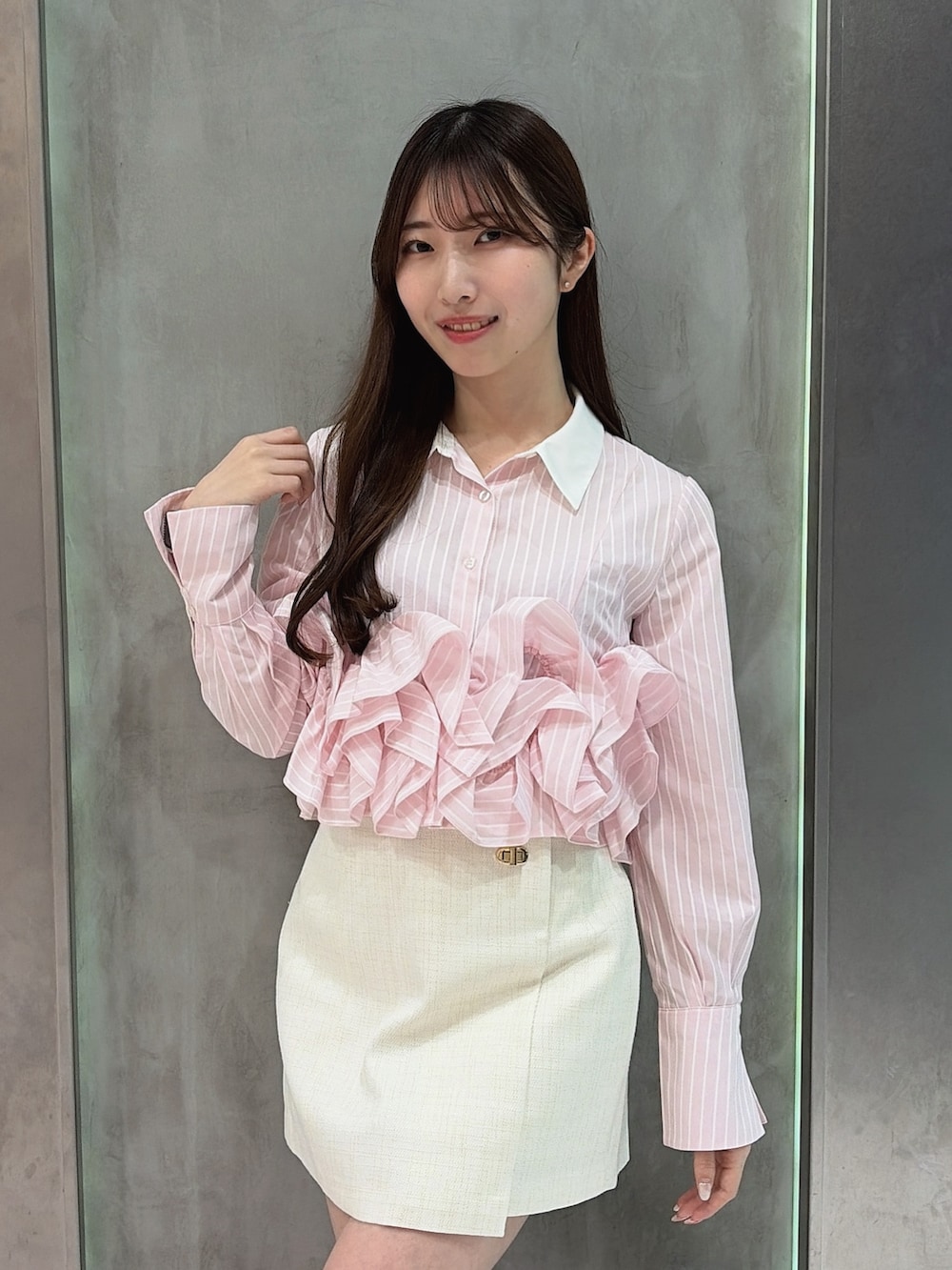 ピンク系のシャツ/ブラウス、ホワイト系のスカート、ホワイト系のブーツを着用したレディースの春コーディネートの6枚目の写真