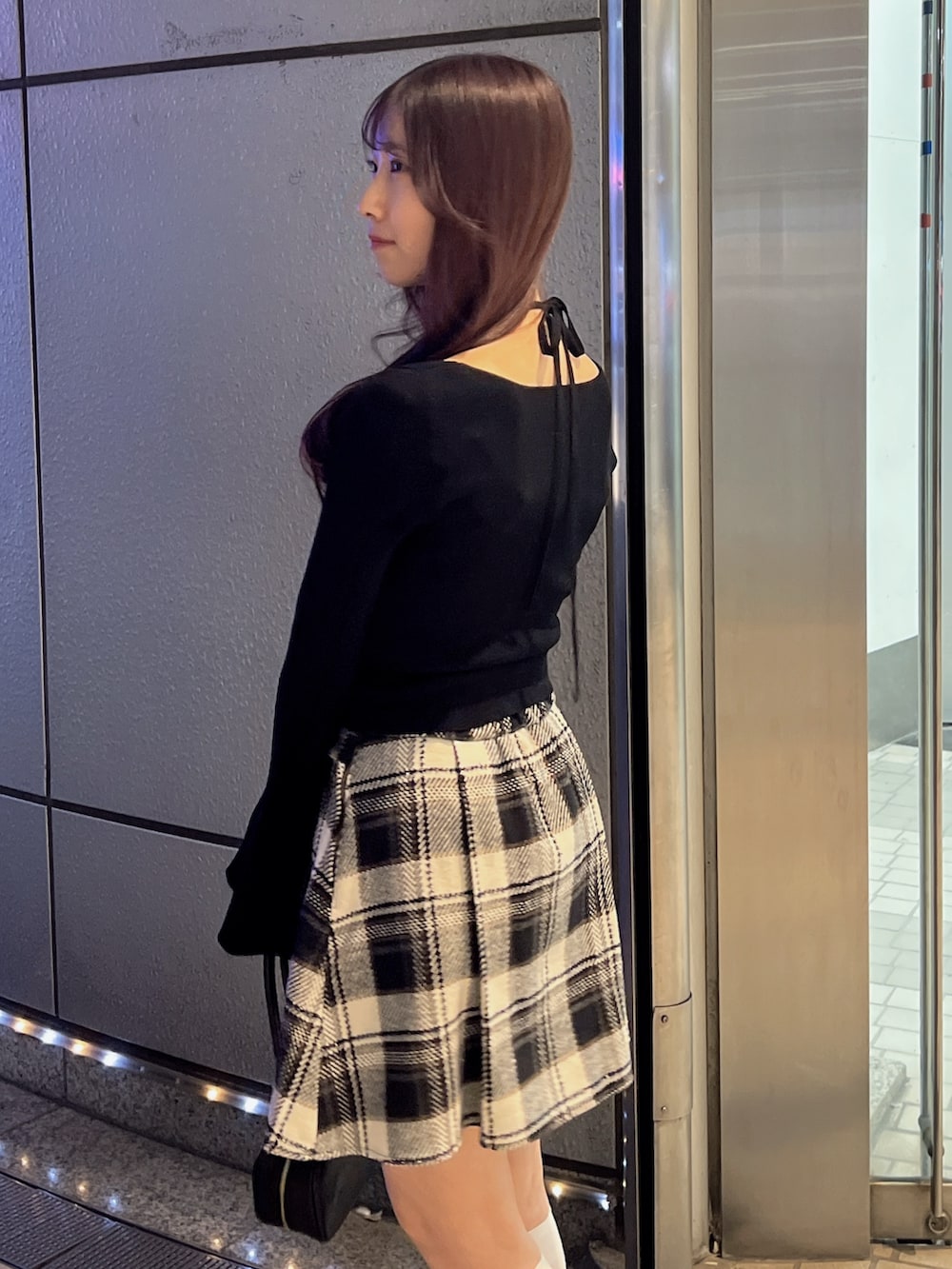 ブラック系のスカート、ブラック系のニット/セーター、ブラウン系のローファーを着用したレディースの冬コーディネートの7枚目の写真