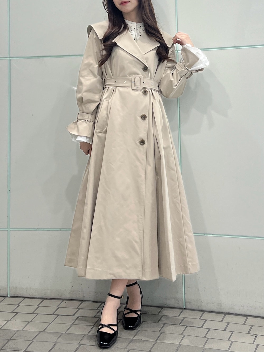 ベージュ系のトレンチコート、ブラック系のサンダルを着用したレディースの冬コーディネートの6枚目の写真