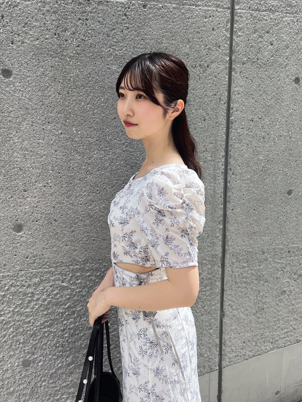 ホワイト系のワンピース、ブラック系のハンドバッグ、ホワイト系のサンダルを着用したレディースの夏コーディネートの6枚目の写真