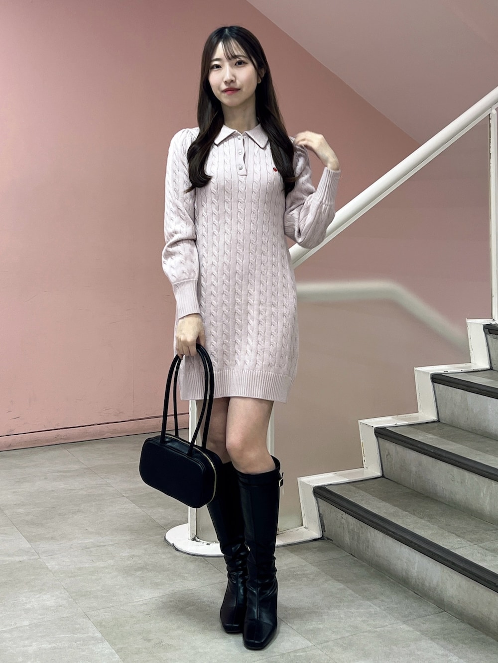 ピンク系のワンピース、ブラック系のブーツ、ブラック系のハンドバッグを着用したレディースの秋コーディネートの2枚目の写真