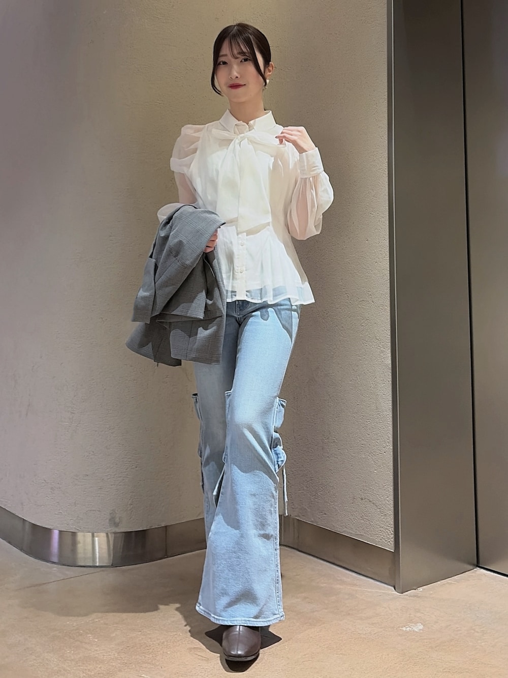 その他のシャツ/ブラウス、グレー系のテーラードジャケット、ブルー系のデニムパンツを着用したレディースの冬コーディネートの2枚目の写真