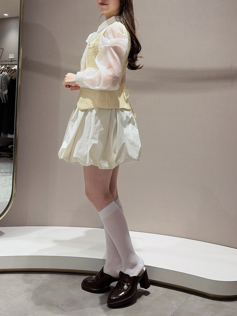 イエロー系のワンピース、その他のシャツ/ブラウス、ブラウン系のパンプスを着用したレディースの春コーディネートの3枚目の写真