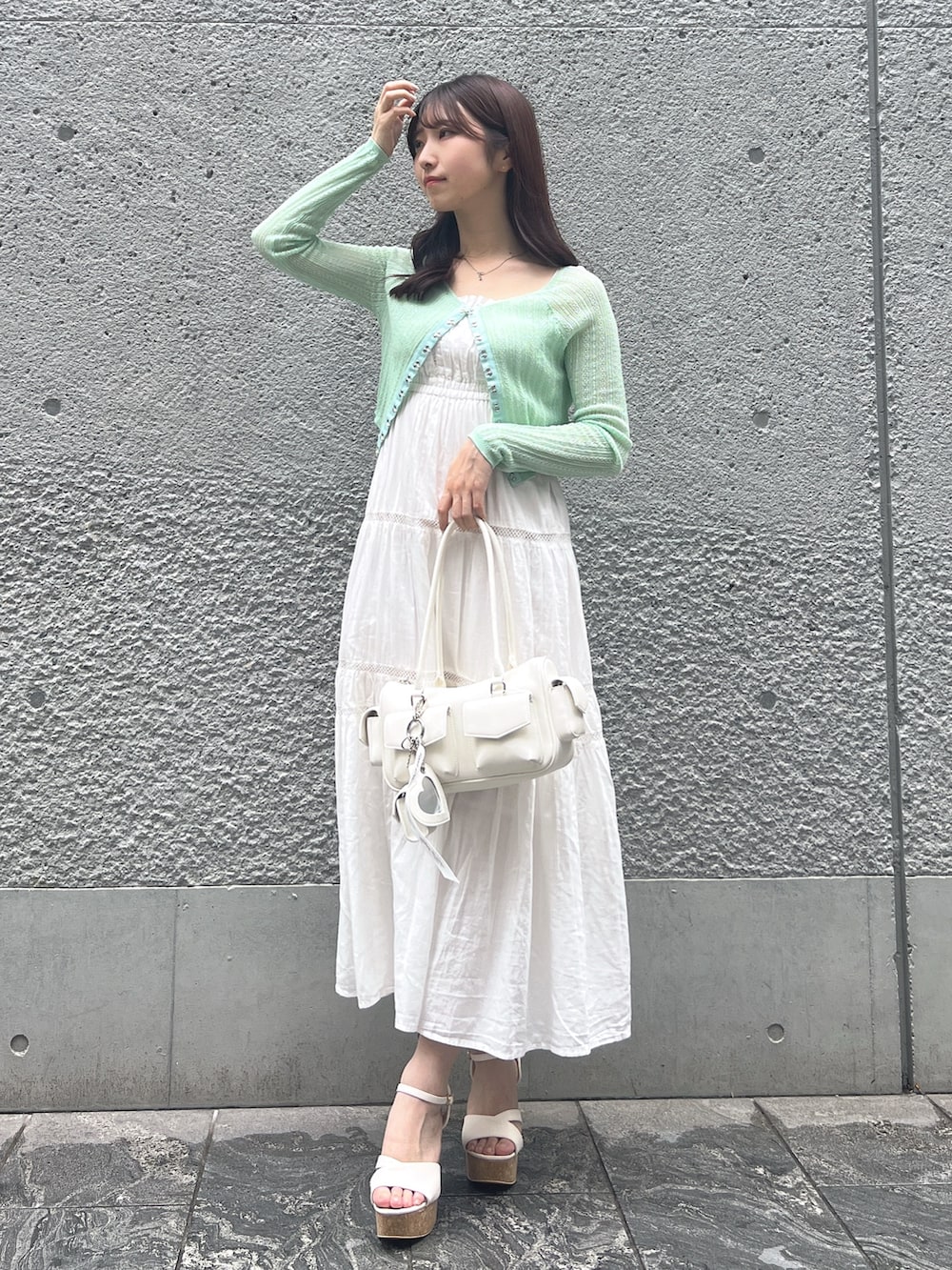 ホワイト系のワンピース、グリーン系のカーディガン/ボレロ、ホワイト系のボストンバッグを着用したレディースの夏コーディネートの7枚目の写真