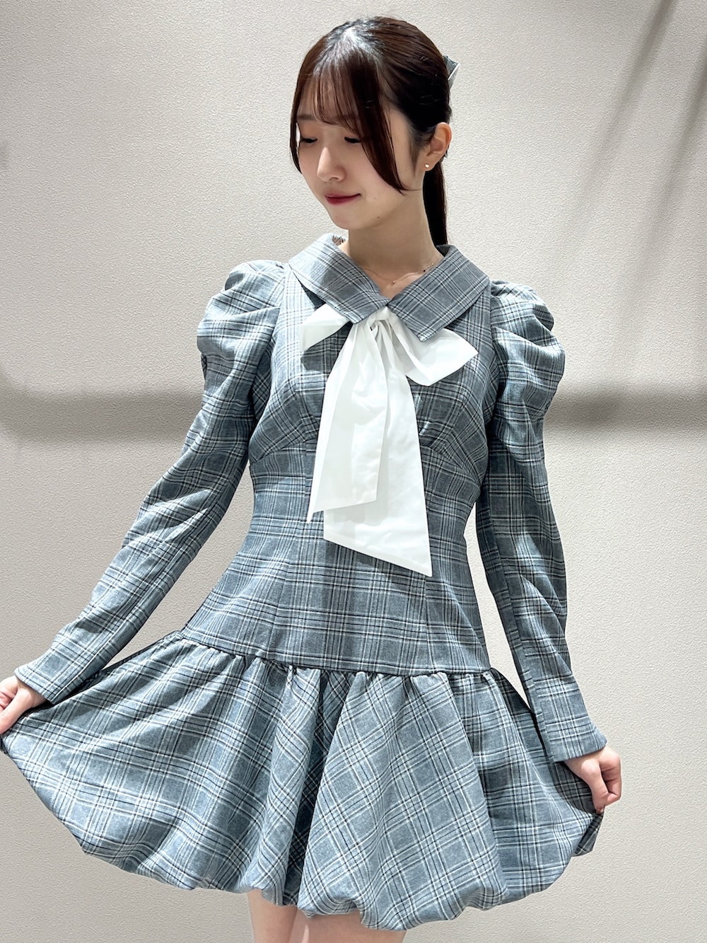 グレー系のワンピース、ブラック系のブーツを着用したレディースの秋コーディネートの6枚目の写真