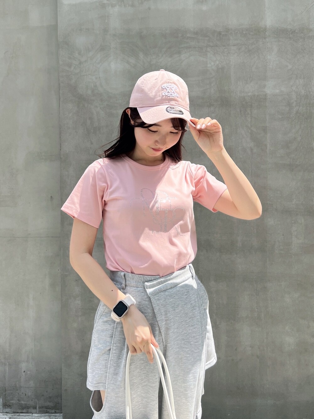 グレー系のカーゴパンツ、ピンク系のTシャツ/カットソー、ホワイト系のボストンバッグを着用したレディースの夏コーディネートの7枚目の写真