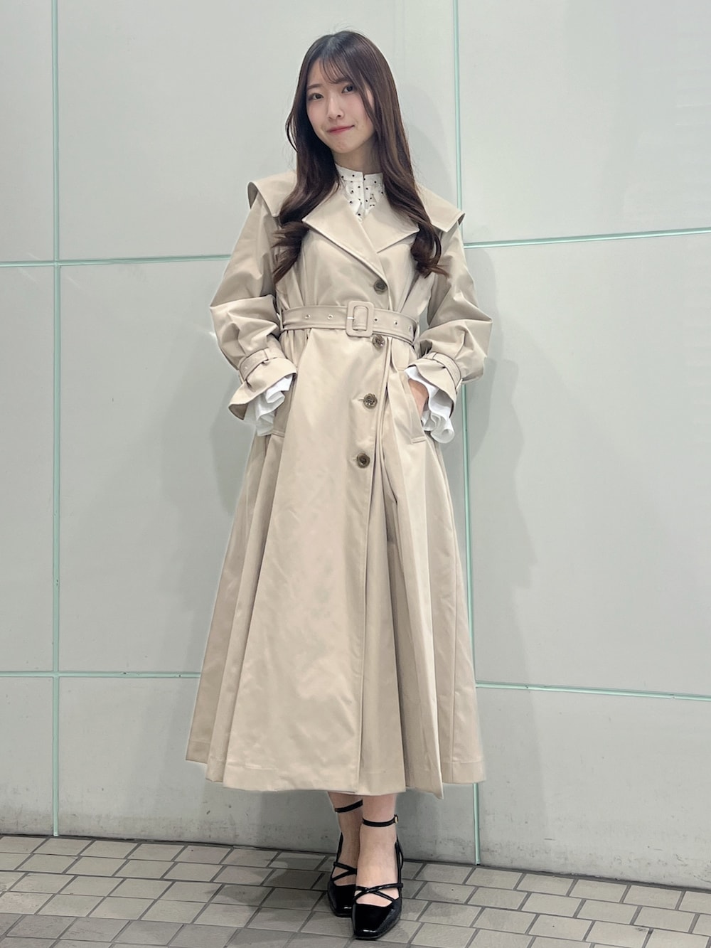 ベージュ系のトレンチコート、ブラック系のサンダルを着用したレディースの冬コーディネートの2枚目の写真