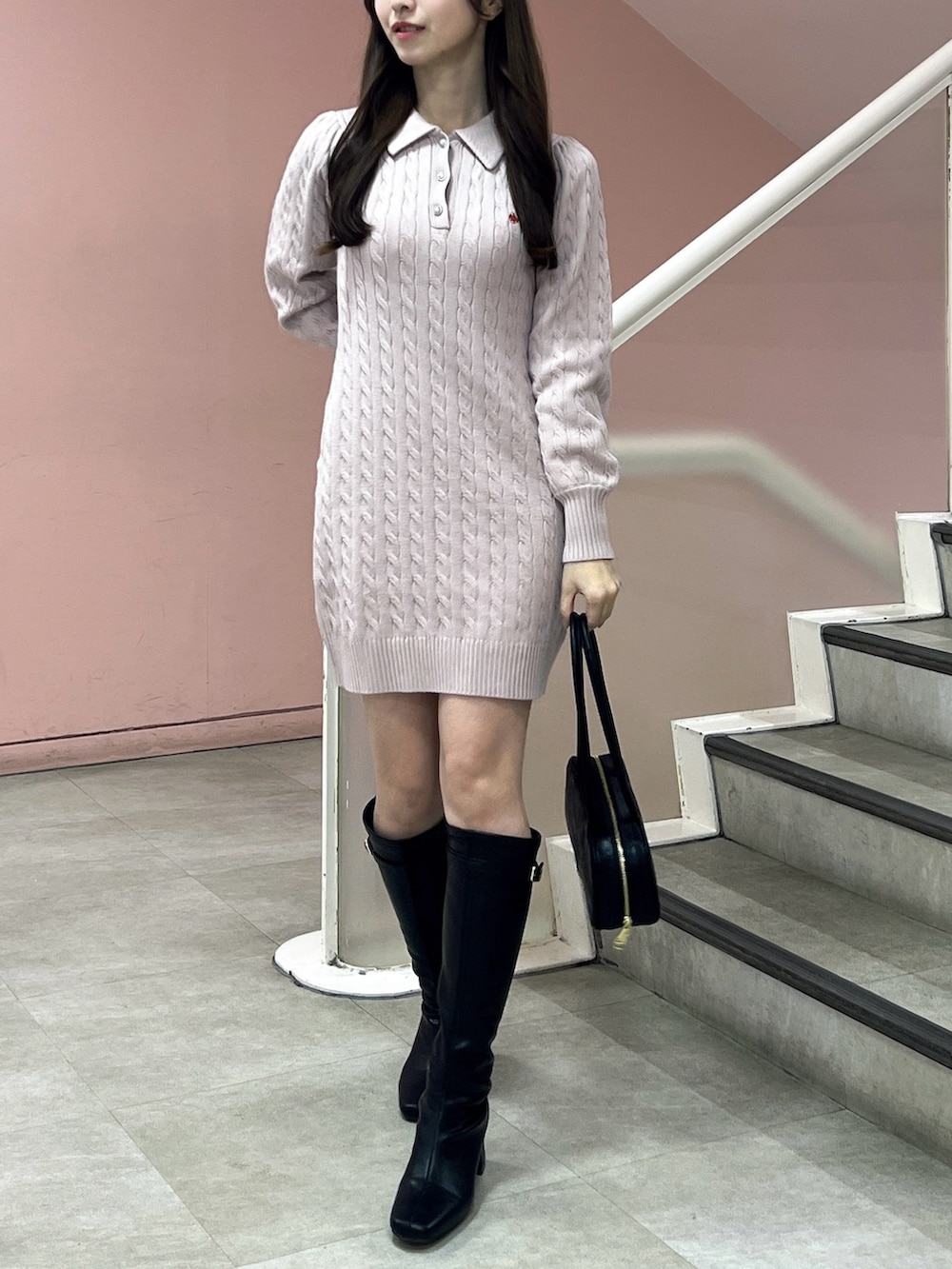 ピンク系のワンピース、ブラック系のブーツ、ブラック系のハンドバッグを着用したレディースの秋コーディネートの3枚目の写真