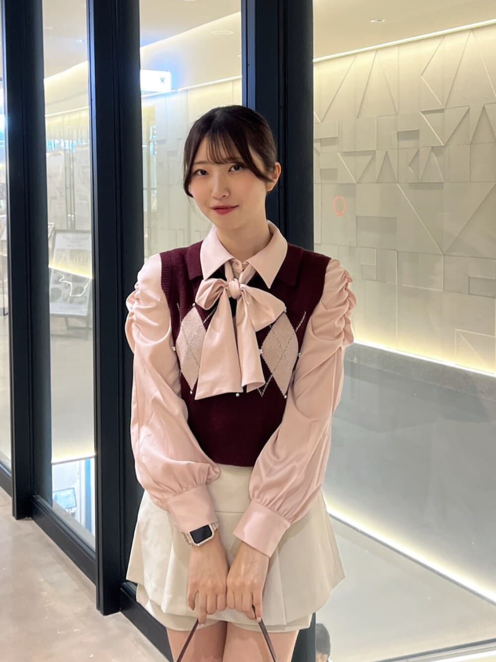 ブラウン系のブーツ、レッド系のハンドバッグ、ホワイト系のスカートを着用したレディースの秋コーディネートの6枚目の写真