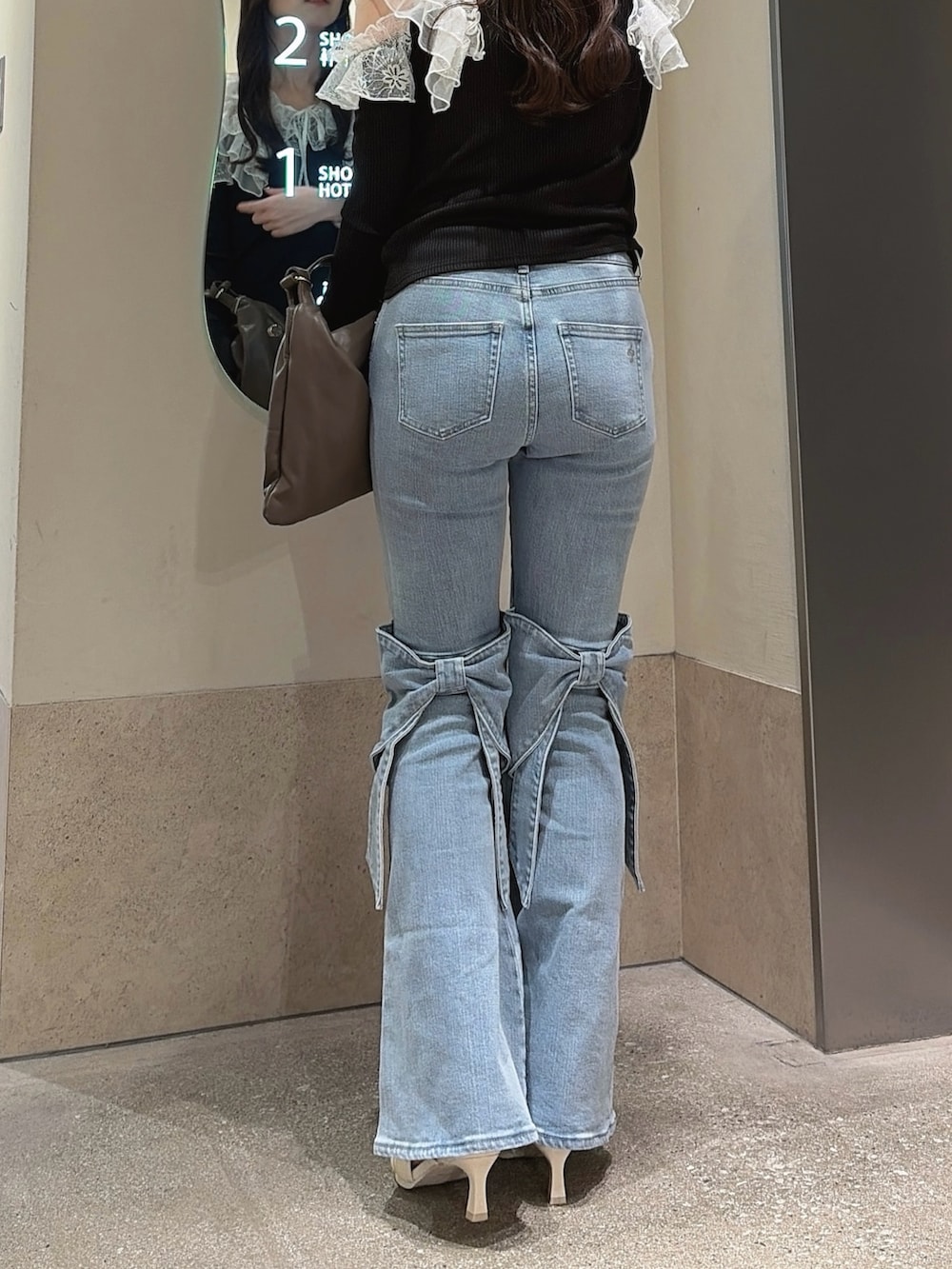 ブラック系のTシャツ/カットソー、ブルー系のデニムパンツ、ブラウン系のハンドバッグを着用したレディースの冬コーディネートの9枚目の写真