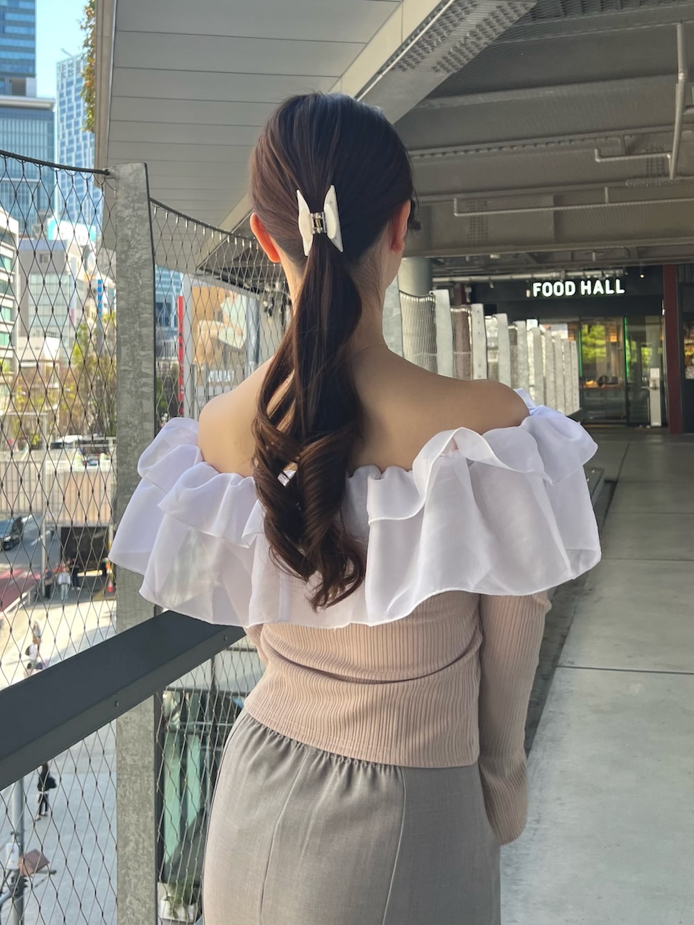 ブルー系のスカート、ピンク系のTシャツ/カットソー、ベージュ系のハンドバッグを着用したレディースの春コーディネートの8枚目の写真