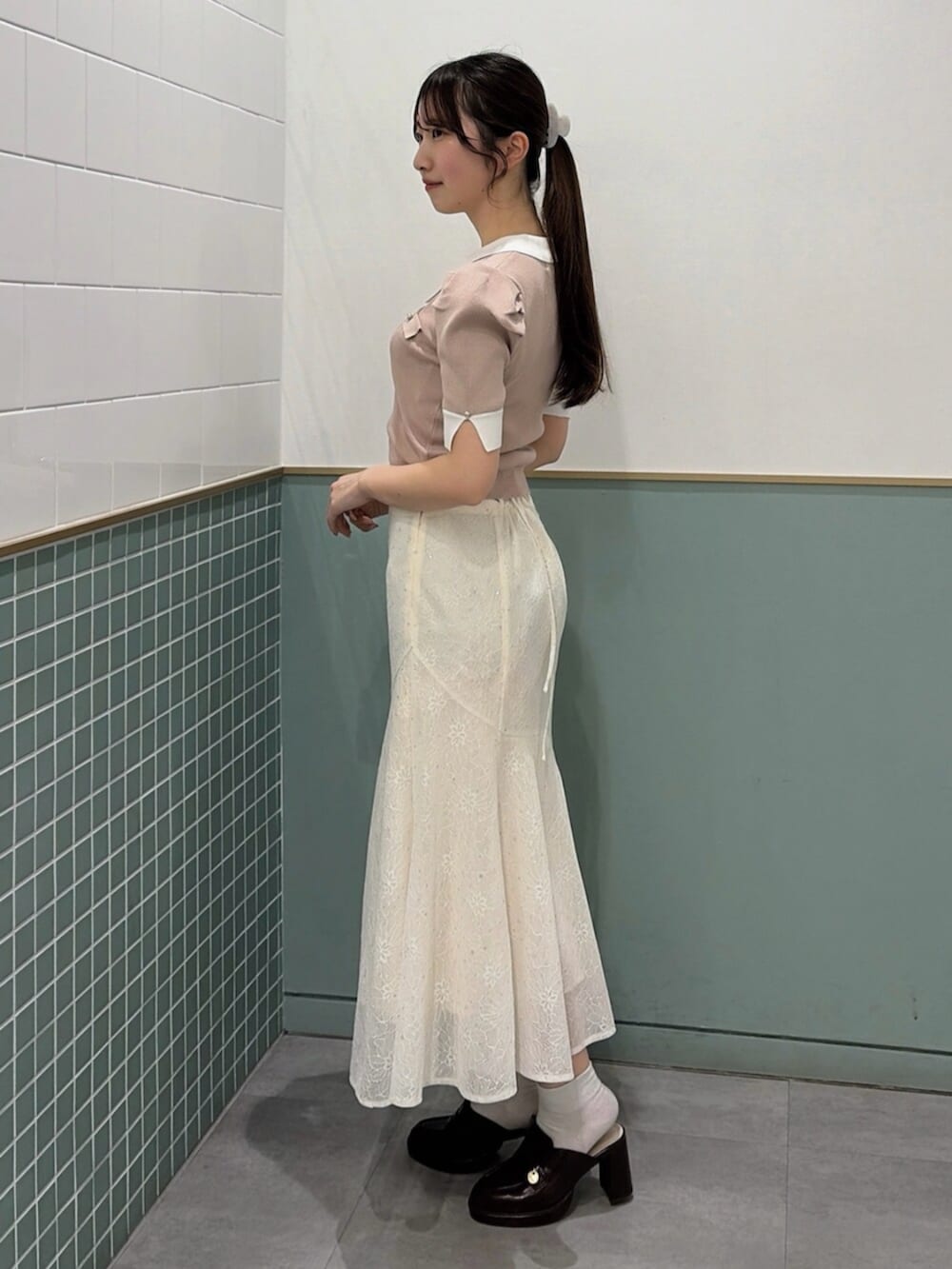 ブラウン系のパンプス、ホワイト系のスカート、ピンク系のニット/セーターを着用したレディースの春コーディネートの3枚目の写真
