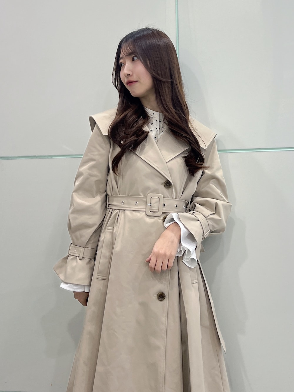 ベージュ系のトレンチコート、ブラック系のサンダルを着用したレディースの冬コーディネートの7枚目の写真