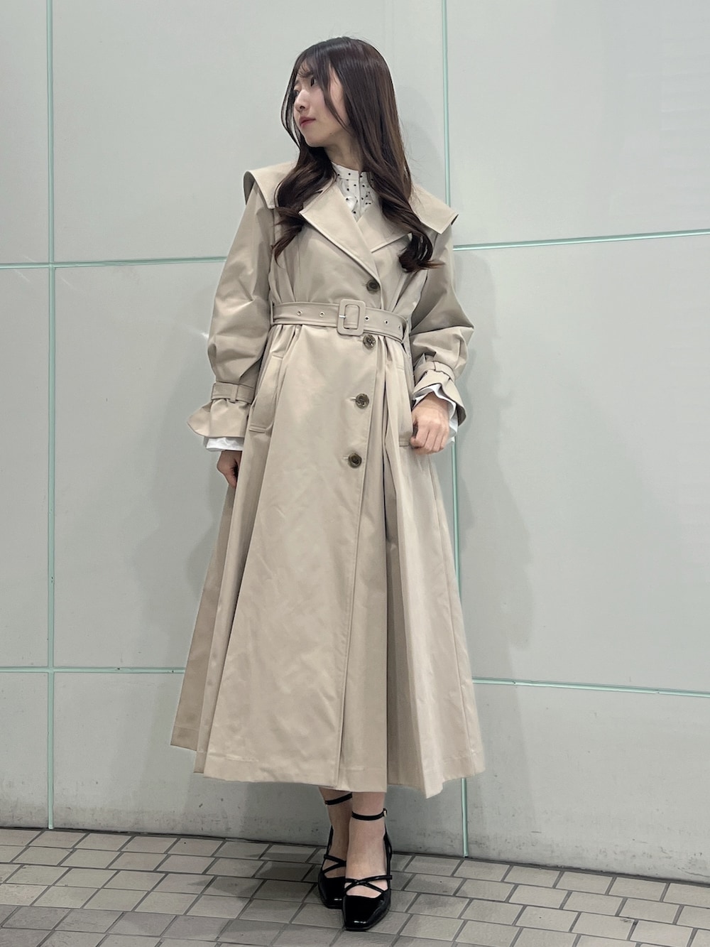 ベージュ系のトレンチコート、ブラック系のサンダルを着用したレディースの冬コーディネートの3枚目の写真