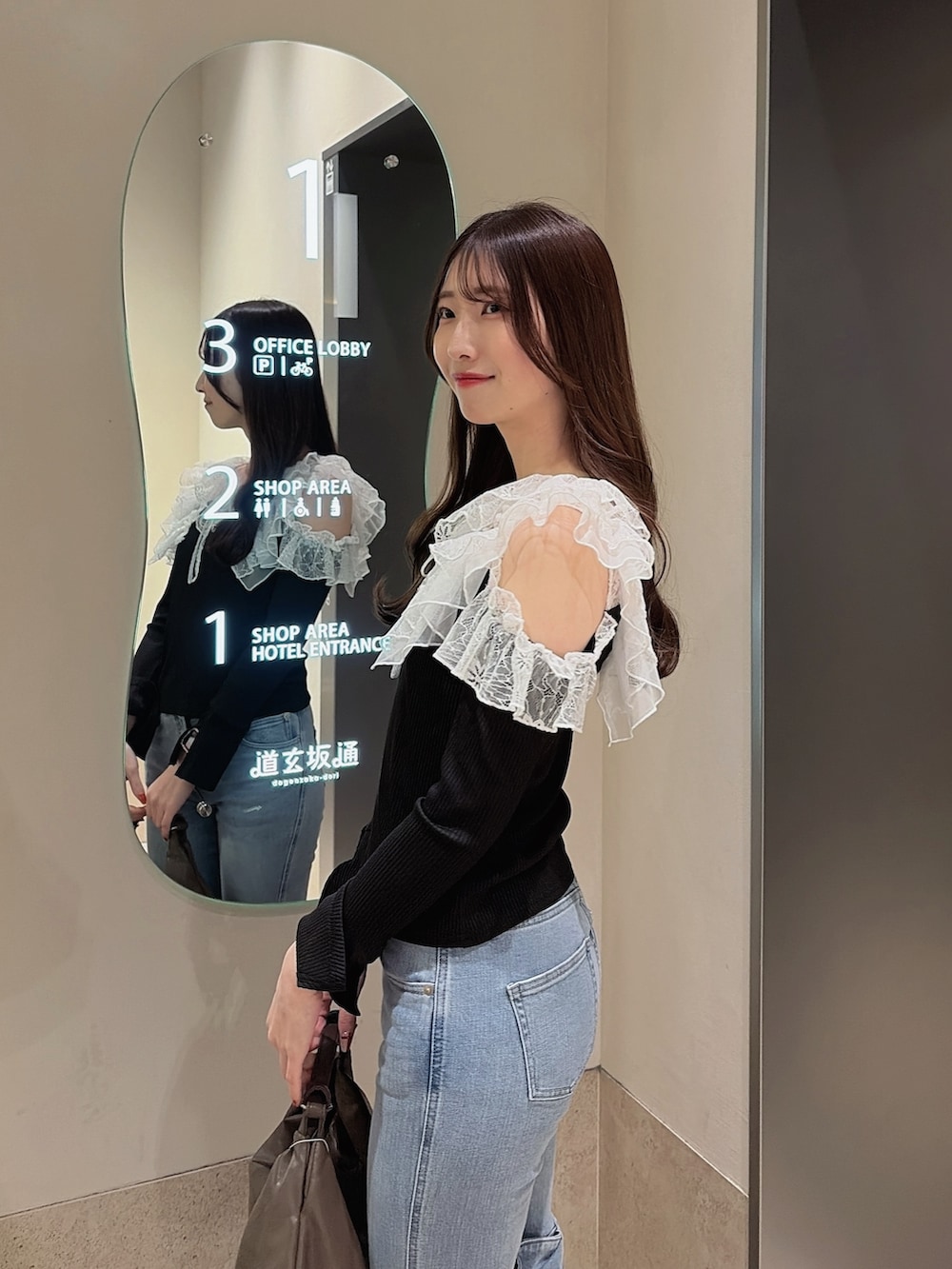 ブラック系のTシャツ/カットソー、ブルー系のデニムパンツ、ブラウン系のハンドバッグを着用したレディースの冬コーディネートの8枚目の写真