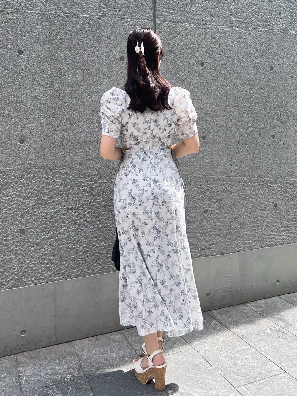 ホワイト系のワンピース、ブラック系のハンドバッグ、ホワイト系のサンダルを着用したレディースの夏コーディネートの4枚目の写真