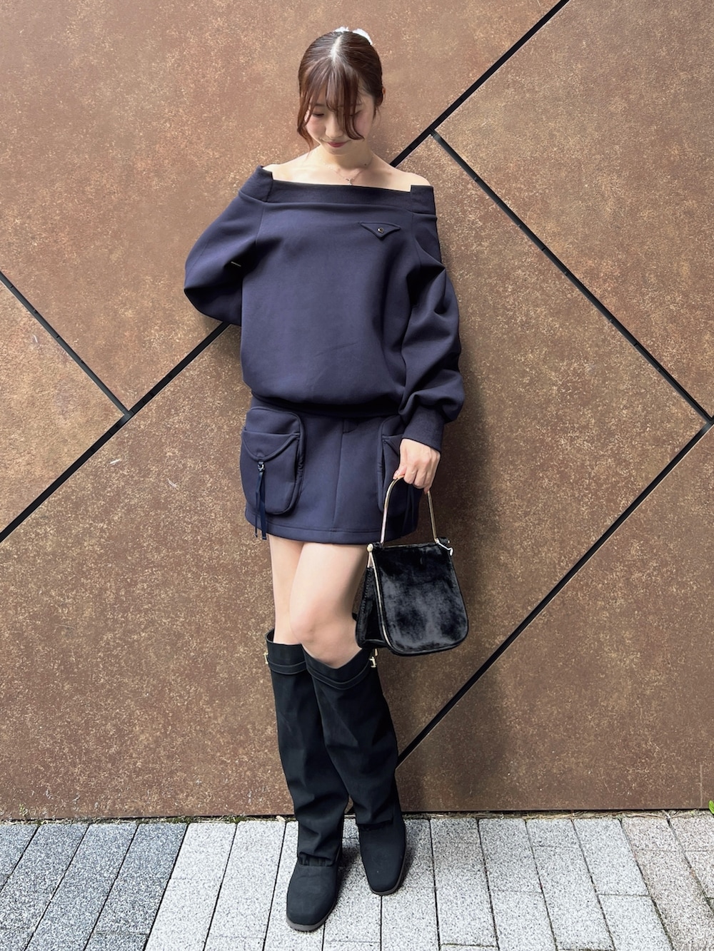 ブルー系のスウェット、ブルー系のスカート、ブラック系のハンドバッグを着用したレディースの秋コーディネートの8枚目の写真