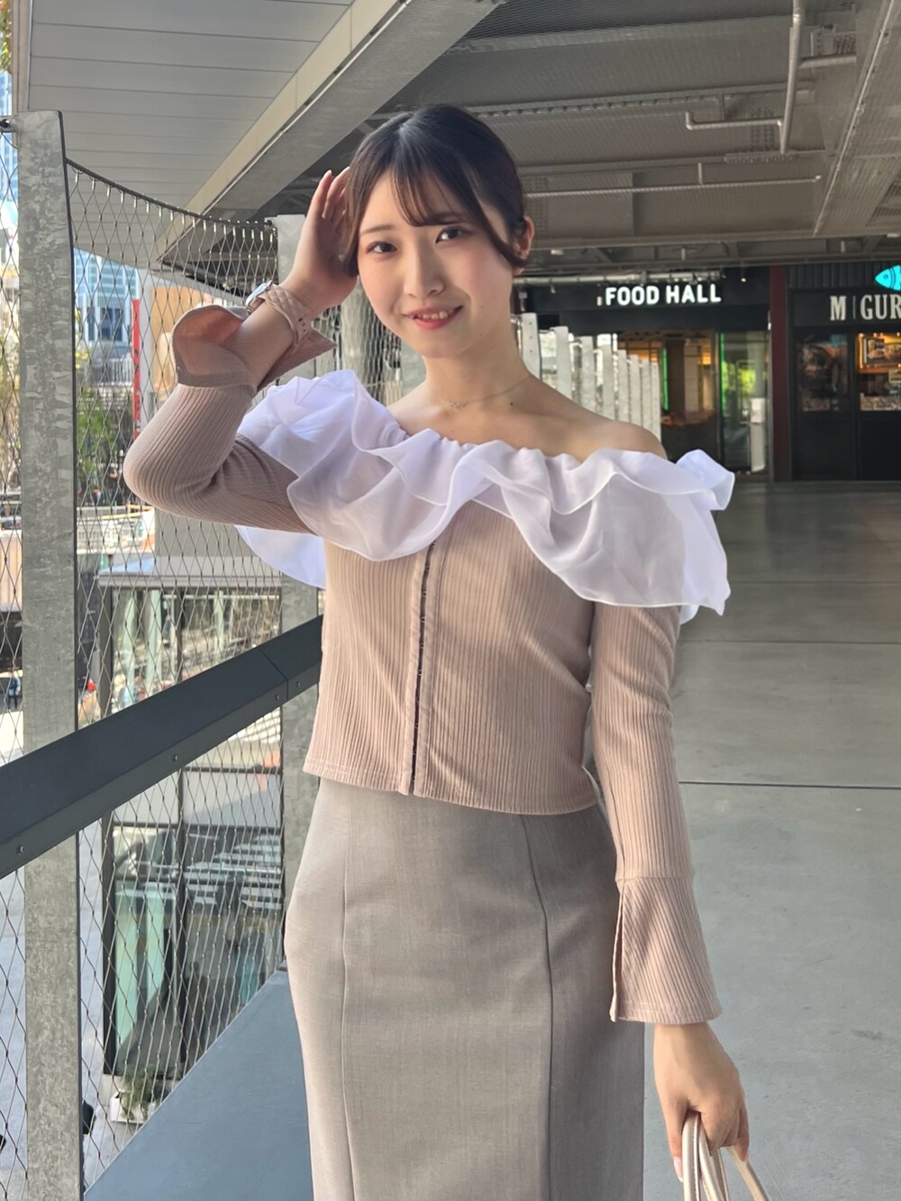 ブルー系のスカート、ピンク系のTシャツ/カットソー、ベージュ系のハンドバッグを着用したレディースの春コーディネートの6枚目の写真