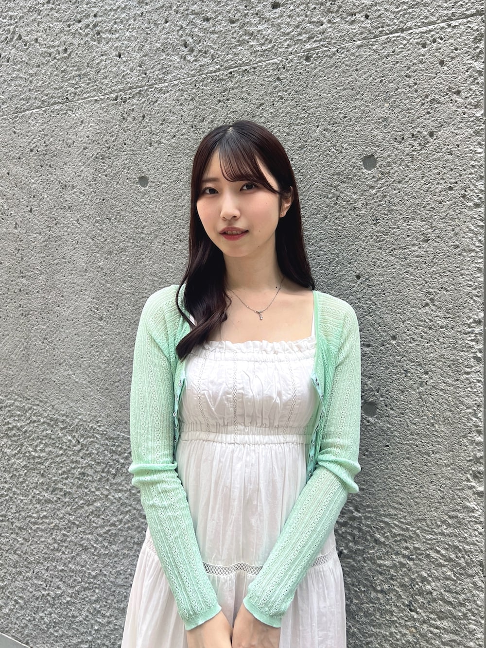 ホワイト系のワンピース、グリーン系のカーディガン/ボレロ、ホワイト系のボストンバッグを着用したレディースの夏コーディネートの3枚目の写真