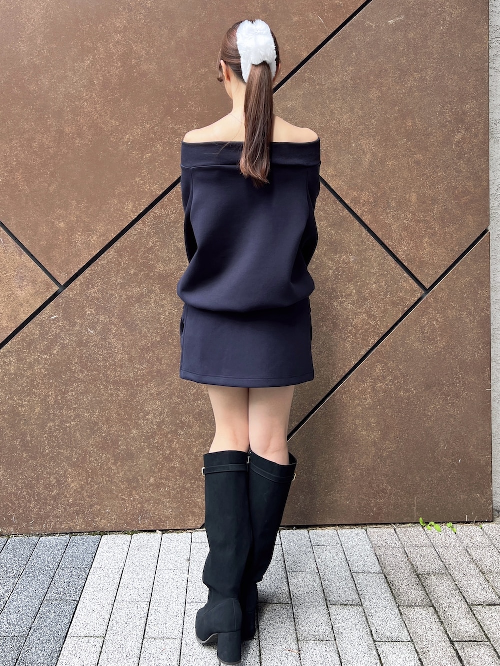 ブルー系のスウェット、ブルー系のスカート、ブラック系のハンドバッグを着用したレディースの秋コーディネートの4枚目の写真