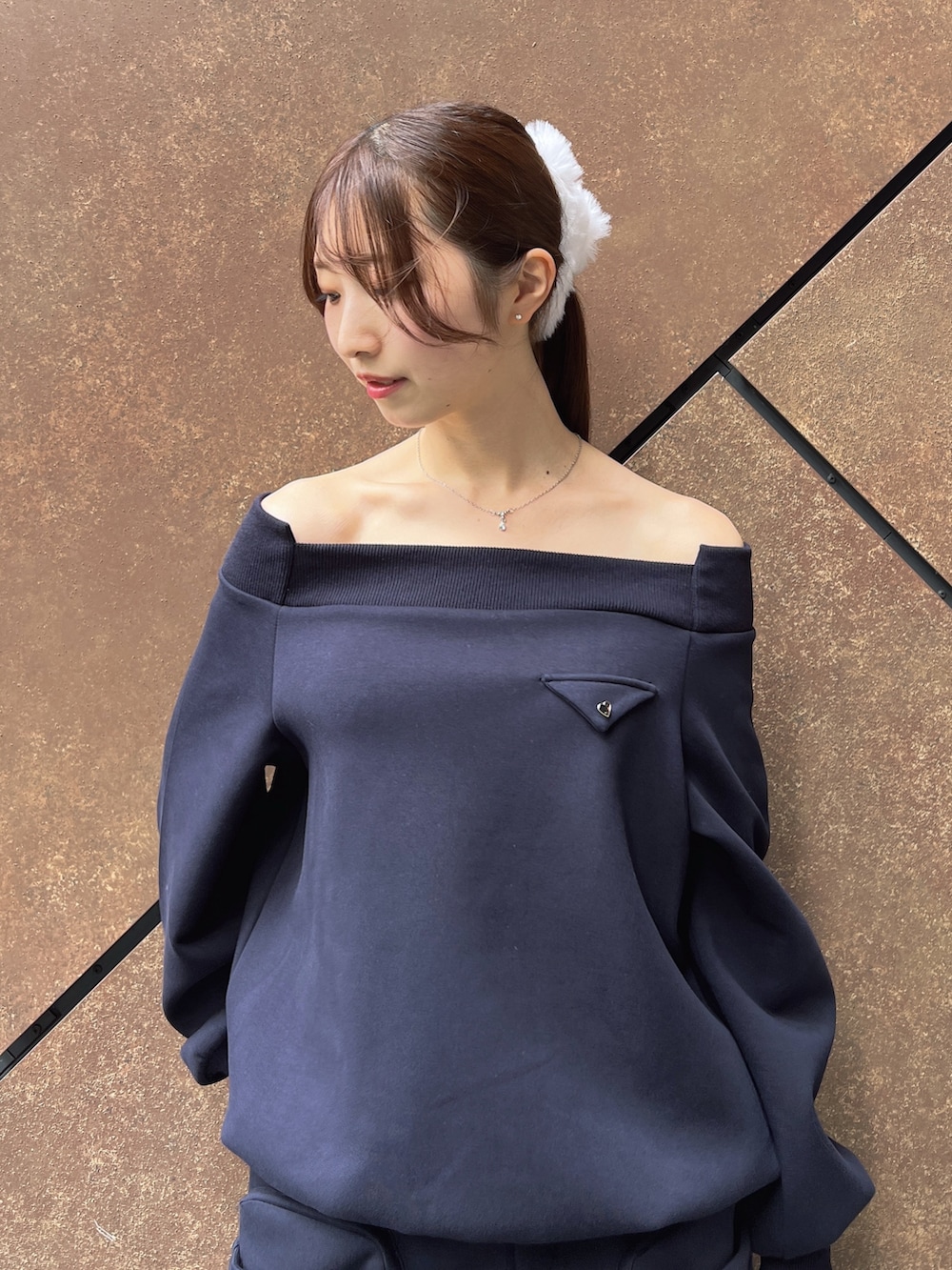 ブルー系のスウェット、ブルー系のスカート、ブラック系のハンドバッグを着用したレディースの秋コーディネートの6枚目の写真