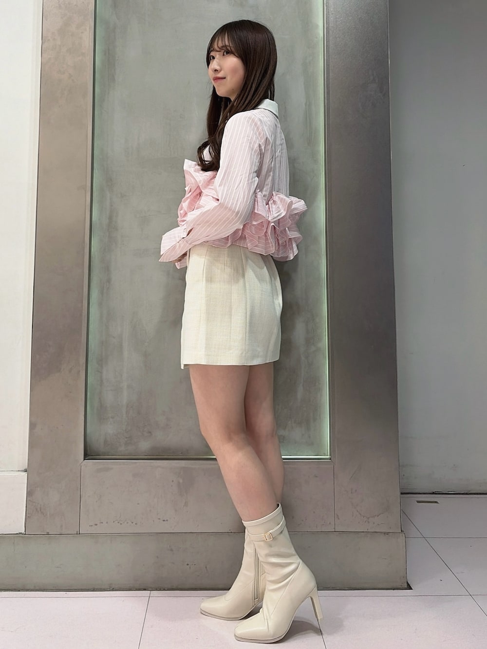 ピンク系のシャツ/ブラウス、ホワイト系のスカート、ホワイト系のブーツを着用したレディースの春コーディネートの3枚目の写真