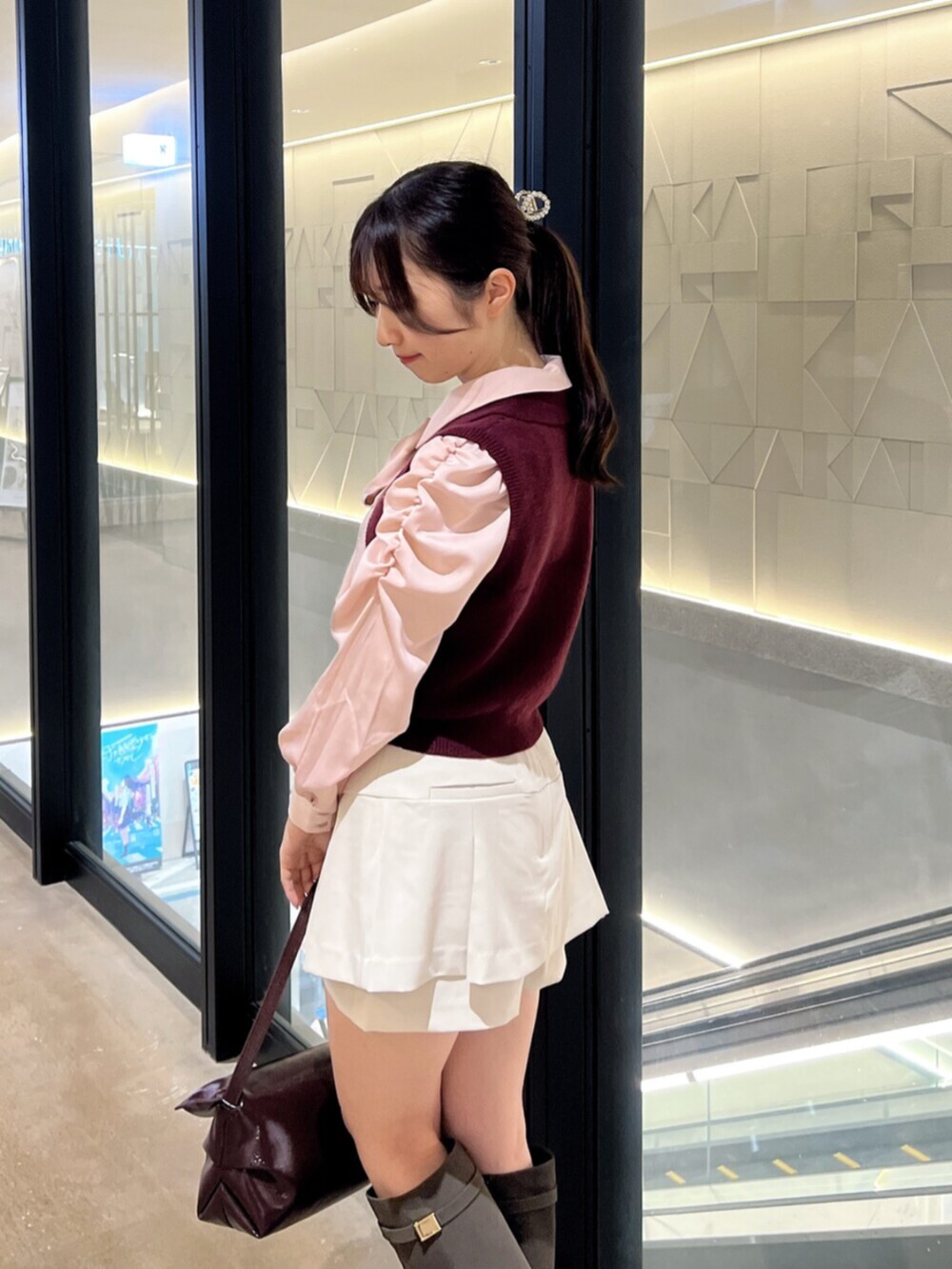 ブラウン系のブーツ、レッド系のハンドバッグ、ホワイト系のスカートを着用したレディースの秋コーディネートの7枚目の写真