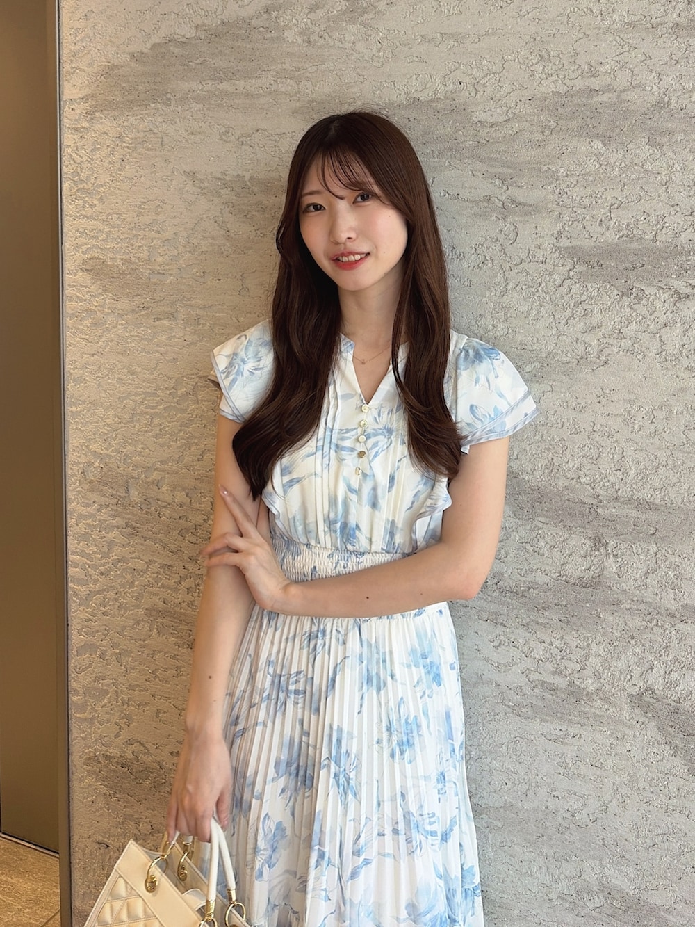 ブラック系のパンプス、ホワイト系のハンドバッグ、ブルー系のワンピースを着用したレディースの夏コーディネートの6枚目の写真