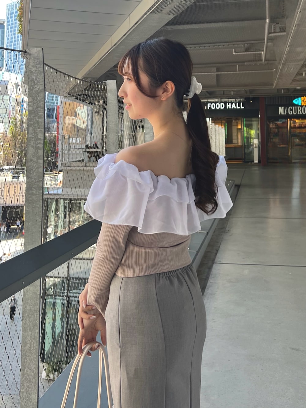 ブルー系のスカート、ピンク系のTシャツ/カットソー、ベージュ系のハンドバッグを着用したレディースの春コーディネートの7枚目の写真