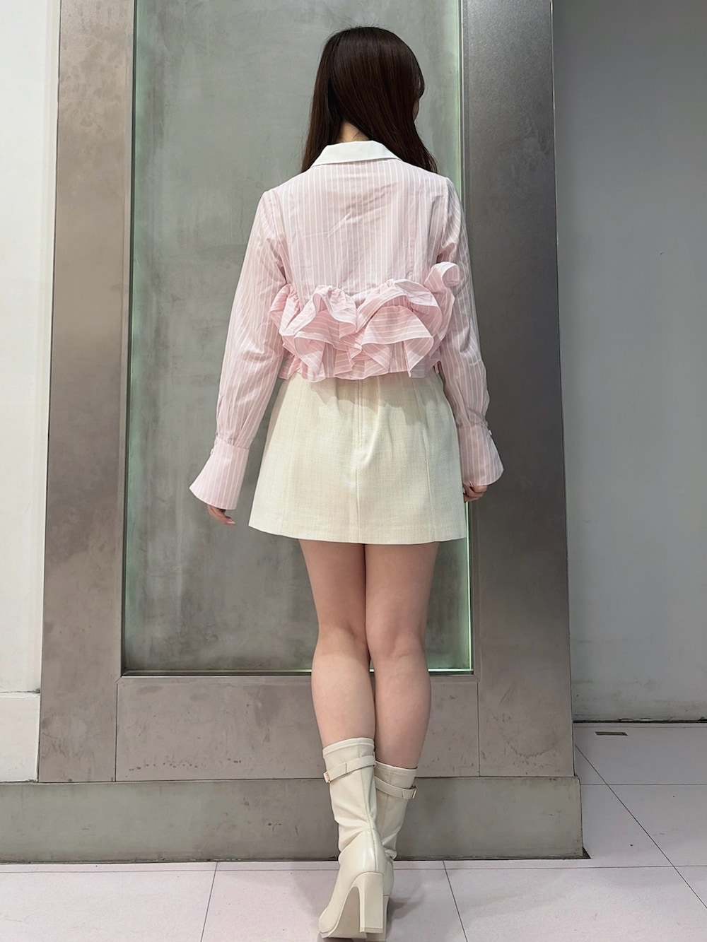 ピンク系のシャツ/ブラウス、ホワイト系のスカート、ホワイト系のブーツを着用したレディースの春コーディネートの4枚目の写真