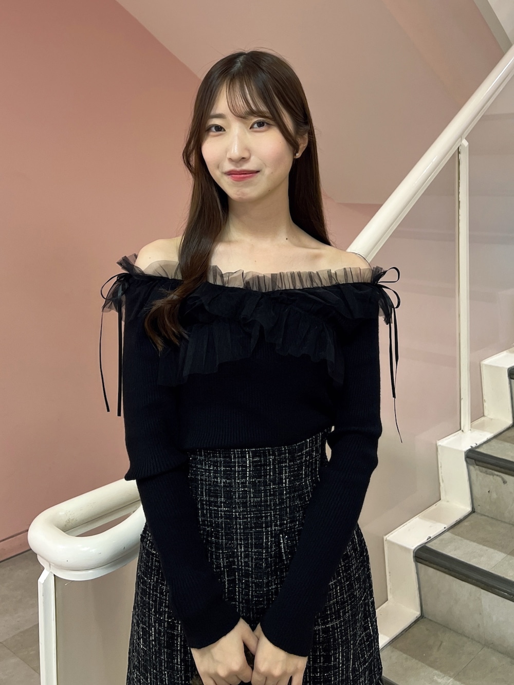 ブラック系のスカート、ブラック系のニット/セーター、ブラウン系のハンドバッグを着用したレディースの秋コーディネートの5枚目の写真