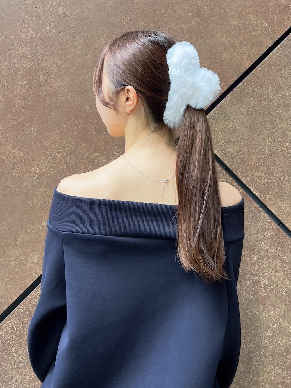 ブルー系のスウェット、ブルー系のスカート、ブラック系のハンドバッグを着用したレディースの秋コーディネートの7枚目の写真