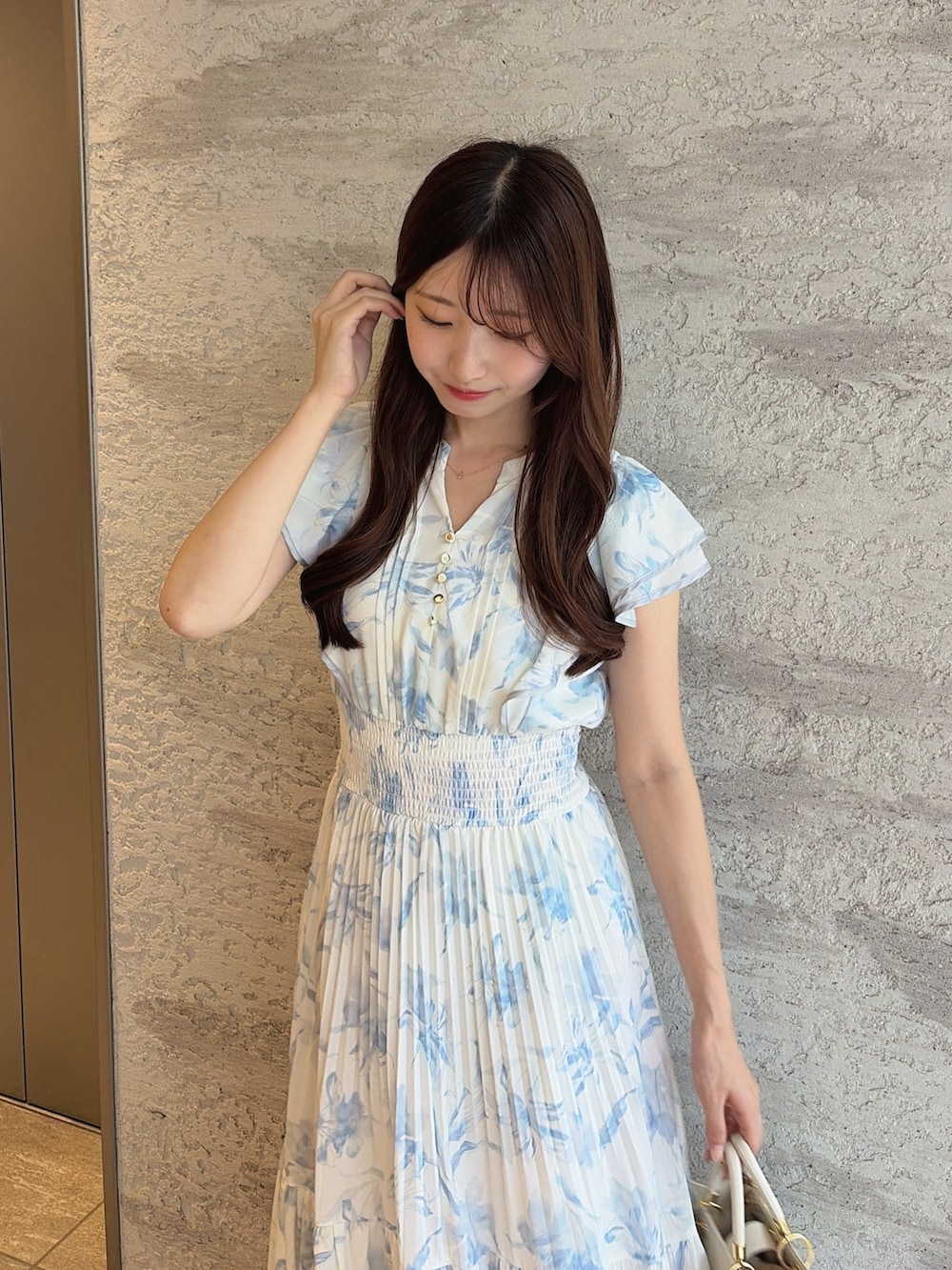 ブラック系のパンプス、ホワイト系のハンドバッグ、ブルー系のワンピースを着用したレディースの夏コーディネートの7枚目の写真
