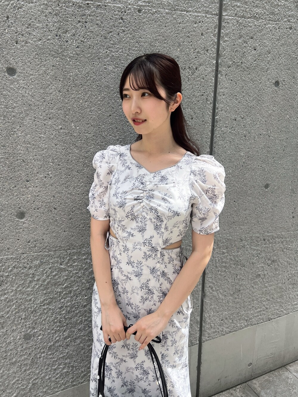 ホワイト系のワンピース、ブラック系のハンドバッグ、ホワイト系のサンダルを着用したレディースの夏コーディネートの5枚目の写真