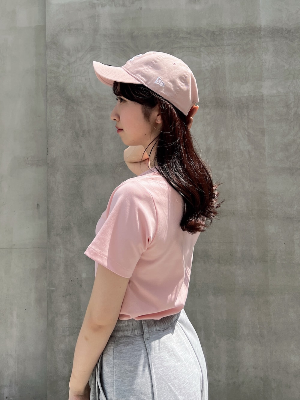 グレー系のカーゴパンツ、ピンク系のTシャツ/カットソー、ホワイト系のボストンバッグを着用したレディースの夏コーディネートの6枚目の写真