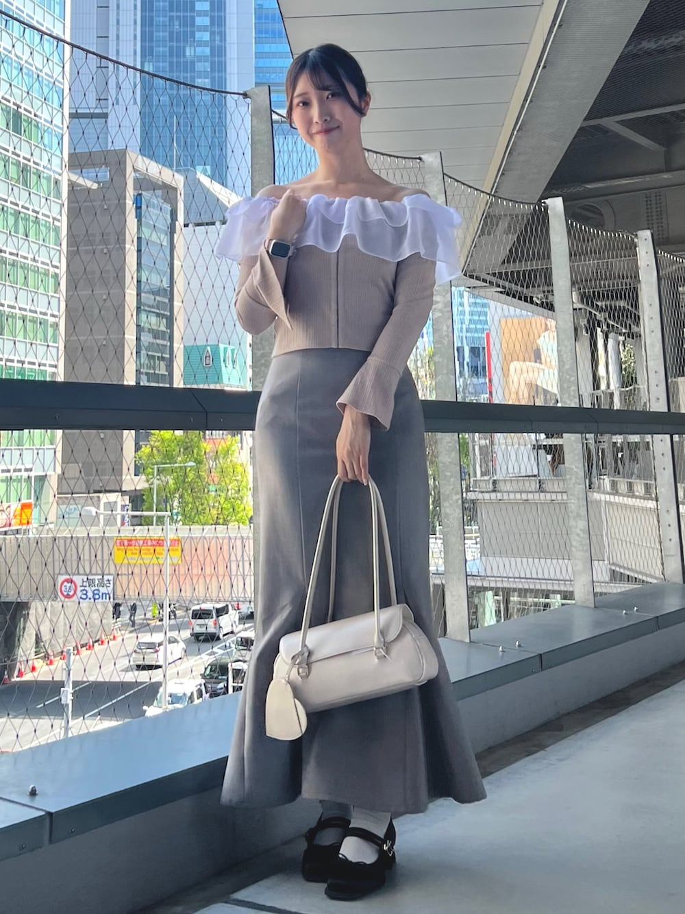 ブルー系のスカート、ピンク系のTシャツ/カットソー、ベージュ系のハンドバッグを着用したレディースの春コーディネートの2枚目の写真