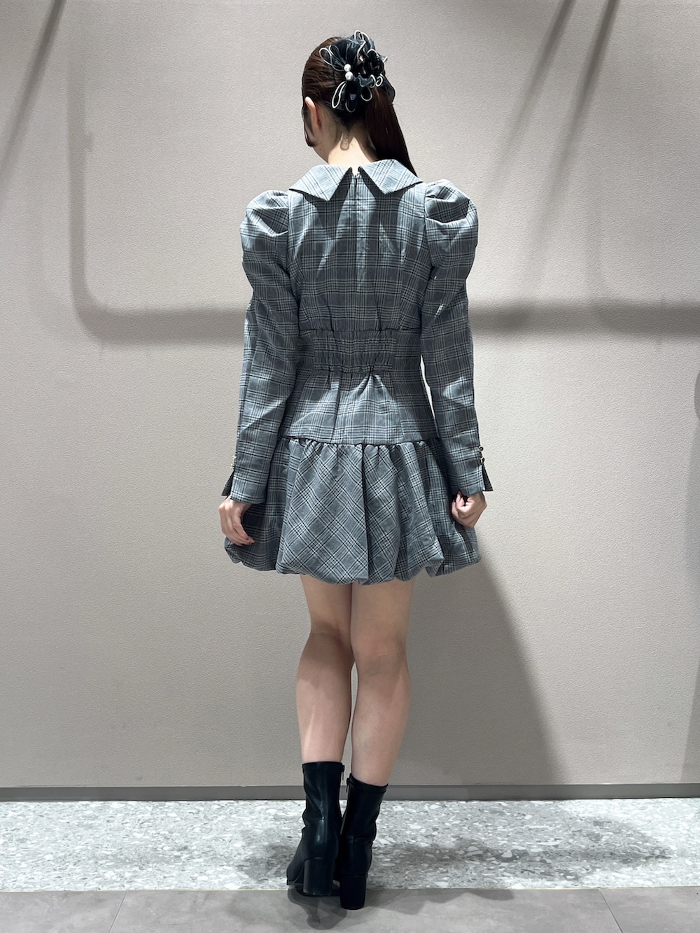 グレー系のワンピース、ブラック系のブーツを着用したレディースの秋コーディネートの3枚目の写真