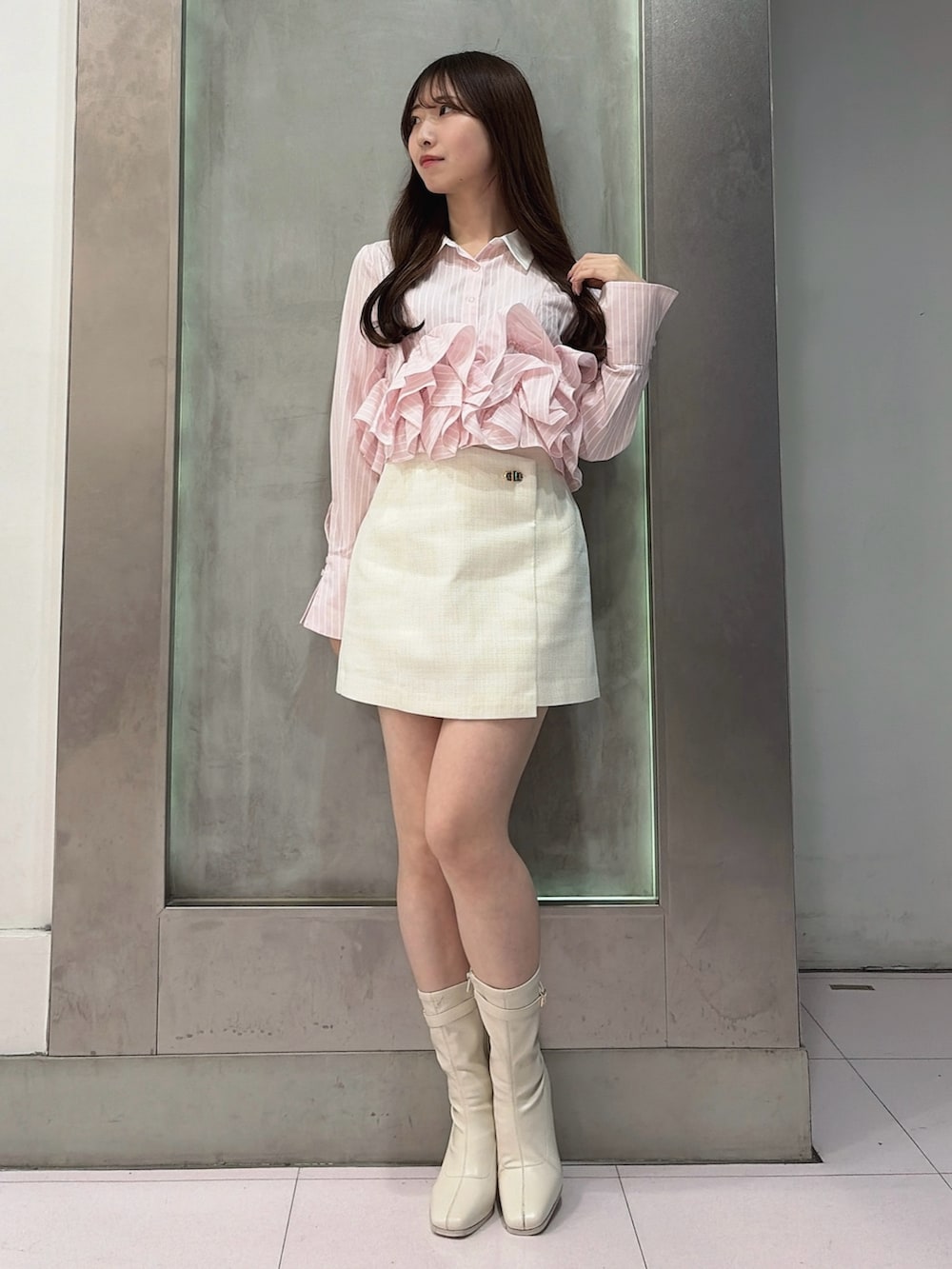 ピンク系のシャツ/ブラウス、ホワイト系のスカート、ホワイト系のブーツを着用したレディースの春コーディネートの5枚目の写真