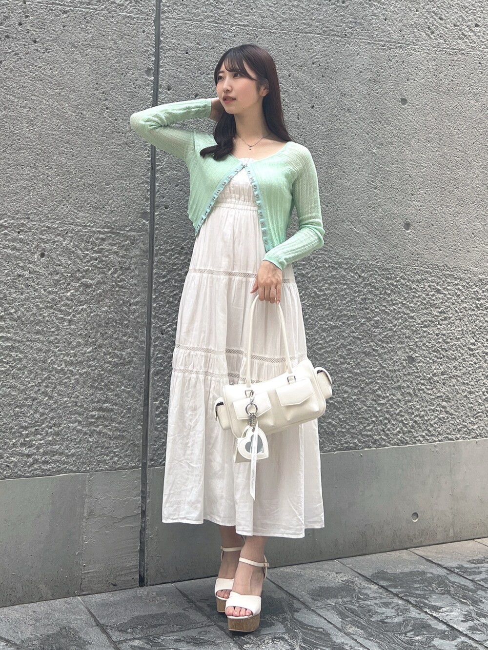 ホワイト系のワンピース、グリーン系のカーディガン/ボレロ、ホワイト系のボストンバッグを着用したレディースの夏コーディネートの2枚目の写真