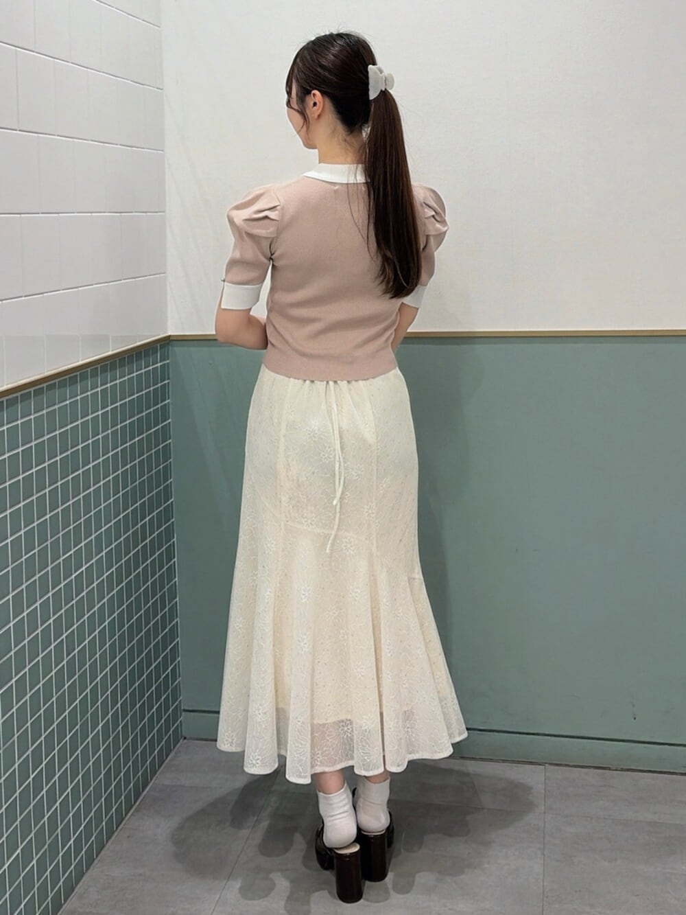 ブラウン系のパンプス、ホワイト系のスカート、ピンク系のニット/セーターを着用したレディースの春コーディネートの4枚目の写真