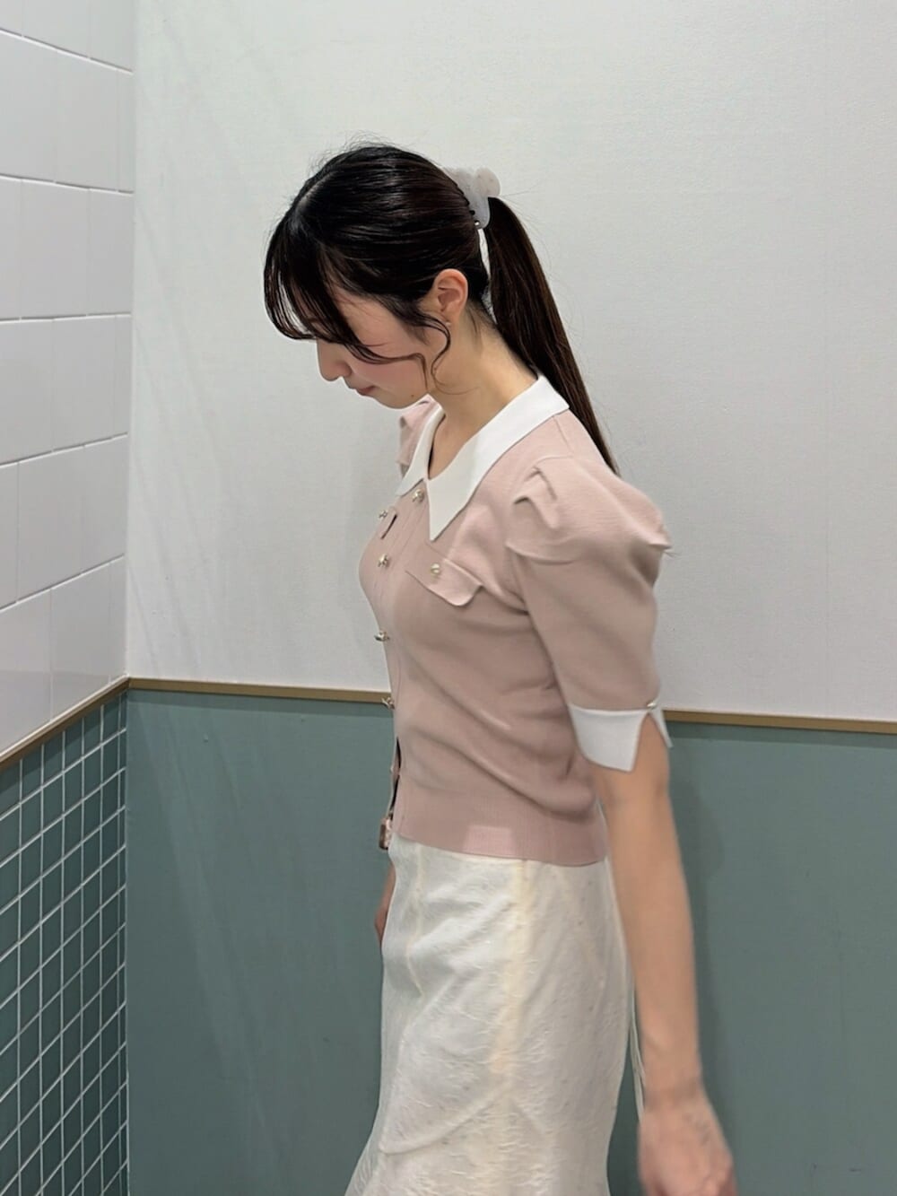 ブラウン系のパンプス、ホワイト系のスカート、ピンク系のニット/セーターを着用したレディースの春コーディネートの6枚目の写真