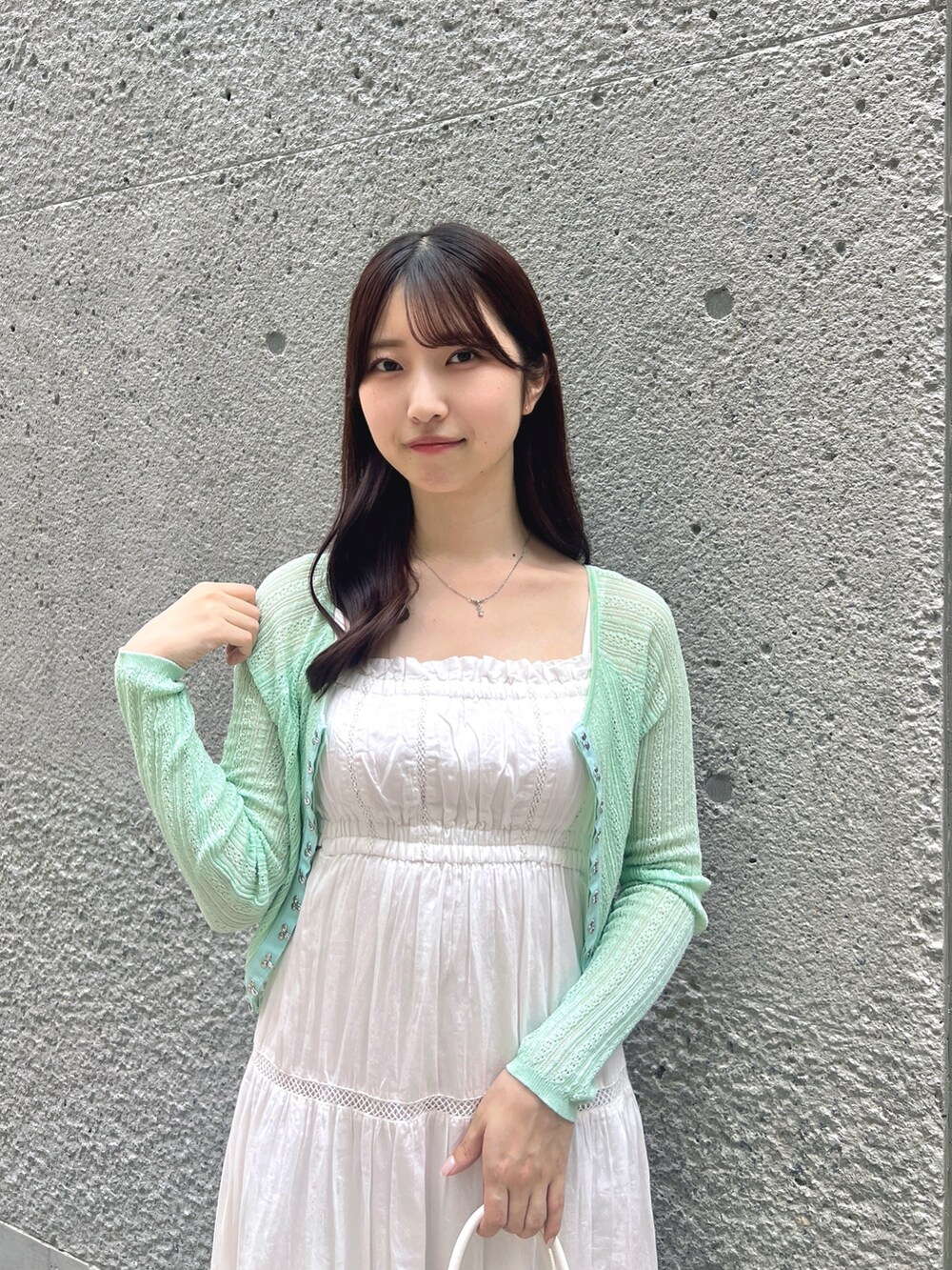 ホワイト系のワンピース、グリーン系のカーディガン/ボレロ、ホワイト系のボストンバッグを着用したレディースの夏コーディネートの4枚目の写真