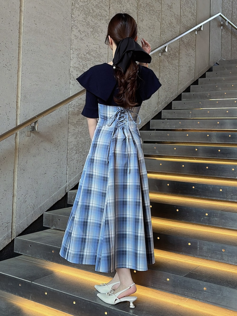 ブルー系のワンピース、ブルー系のハンドバッグ、ホワイト系のパンプスを着用したレディースの春コーディネートの4枚目の写真